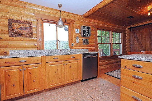 kitchen featuring light stone counters, pendant lighting, a barn door, a sink, and dishwasher