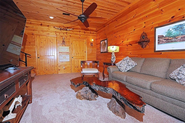 living area with lofted ceiling, wooden ceiling, wooden walls, carpet floors, and a ceiling fan