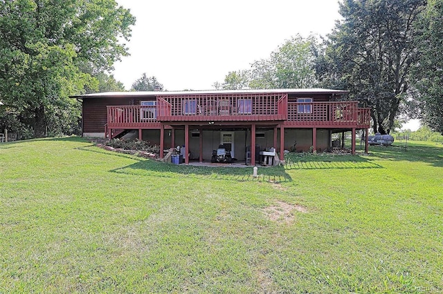 rear view of property featuring a lawn, a wooden deck, and a patio