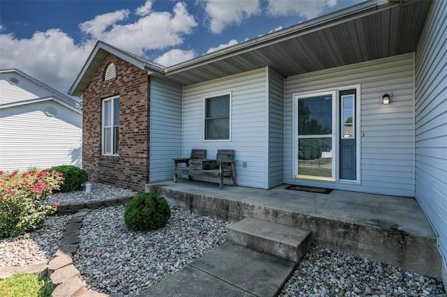 view of exterior entry with a patio area