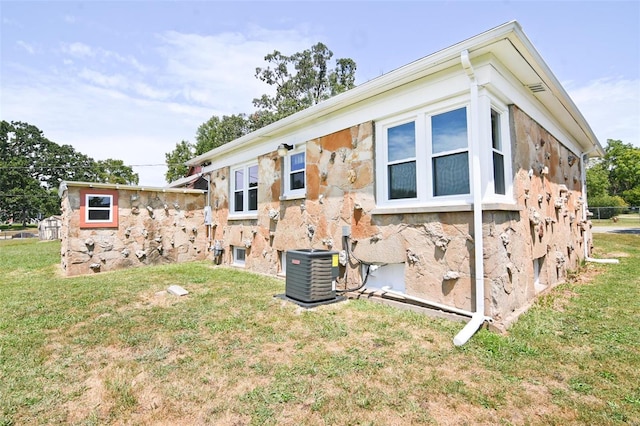 back of property with a lawn and cooling unit