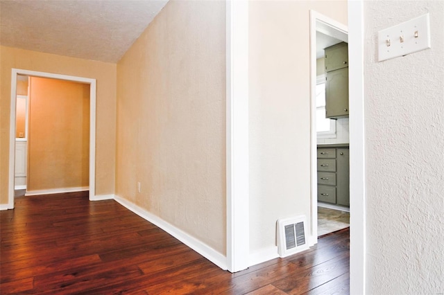 hall featuring a textured ceiling and hardwood / wood-style flooring