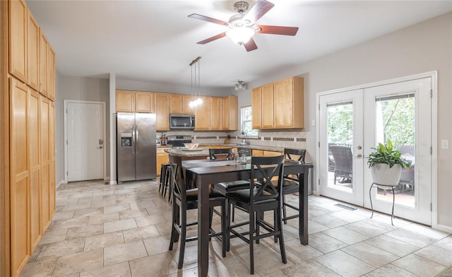 kitchen featuring french doors, stainless steel appliances, backsplash, light brown cabinets, and plenty of natural light