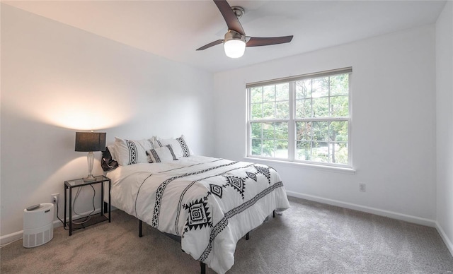 carpeted bedroom with ceiling fan and baseboards