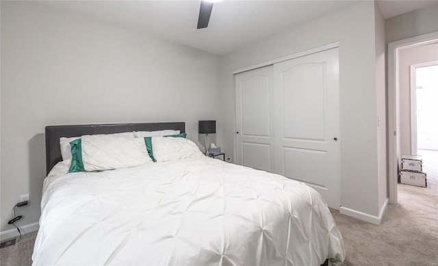 carpeted bedroom with a closet, a ceiling fan, and baseboards