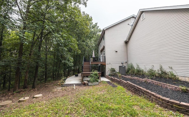 view of yard with a patio, central AC unit, stairway, and a wooden deck