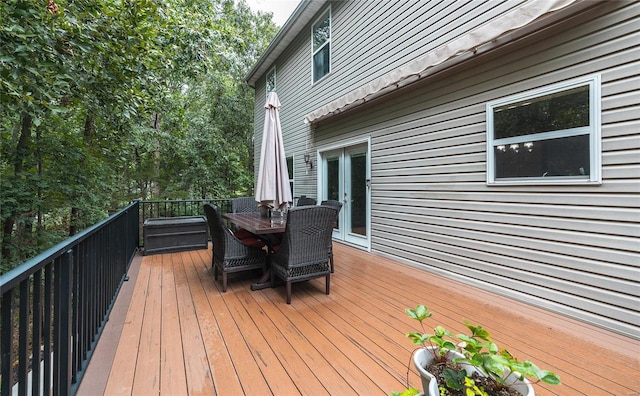 wooden terrace featuring french doors and outdoor dining area