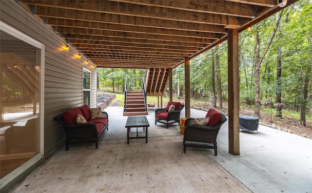 view of patio with an outdoor hangout area, a forest view, and stairs