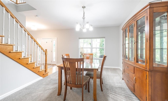 dining space with stairs, light carpet, a chandelier, and baseboards