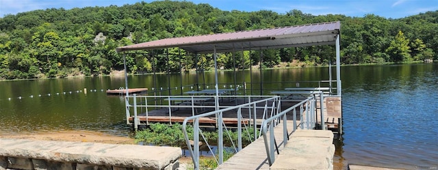 view of dock featuring a water view and a wooded view