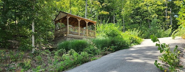 exterior space featuring driveway and a forest view