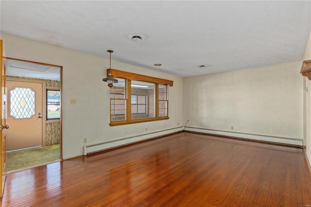 empty room with hardwood / wood-style floors and baseboard heating