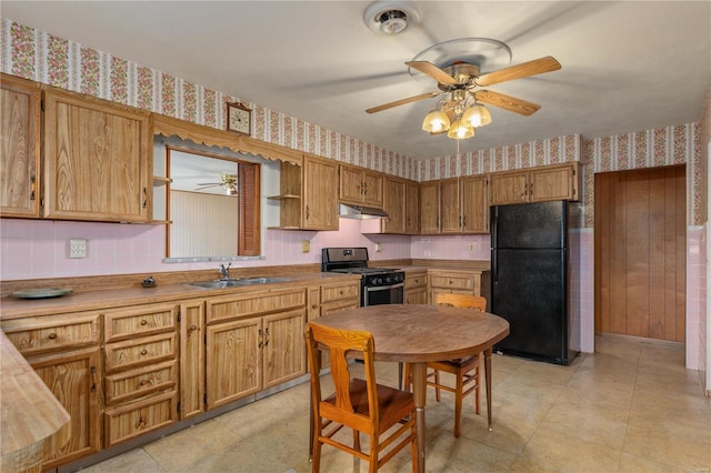 kitchen featuring black fridge, stainless steel range with gas stovetop, sink, and ceiling fan