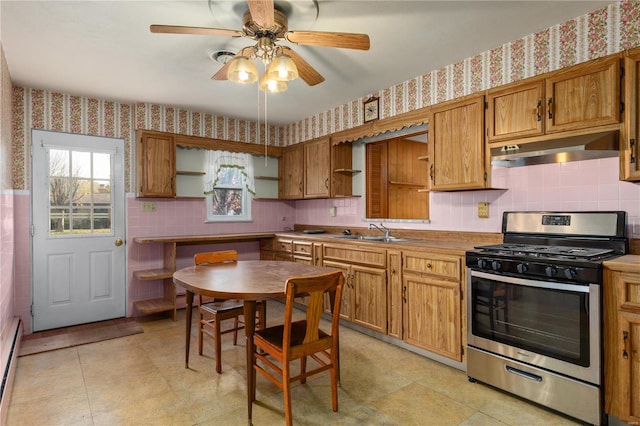 kitchen with a baseboard heating unit, sink, tasteful backsplash, ceiling fan, and stainless steel gas range