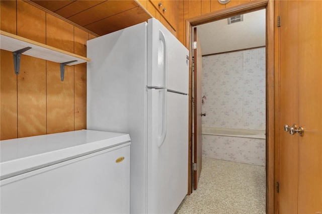 interior space with wood walls and white refrigerator