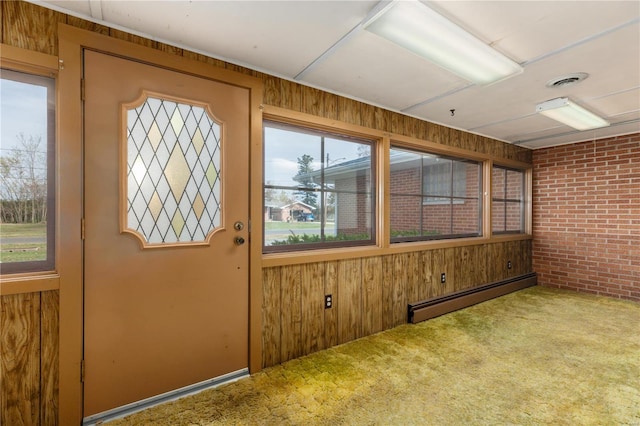 unfurnished sunroom featuring a baseboard heating unit and plenty of natural light