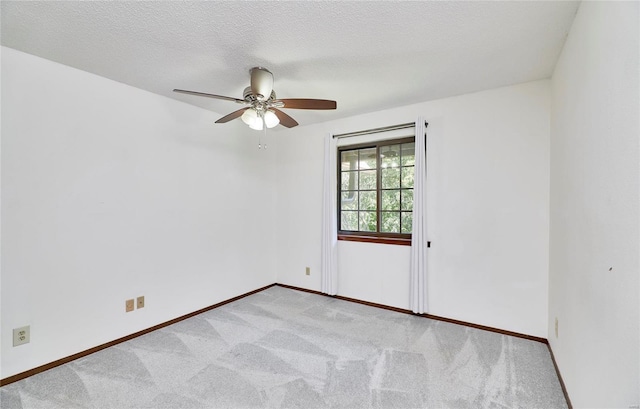 empty room with carpet, baseboards, ceiling fan, and a textured ceiling