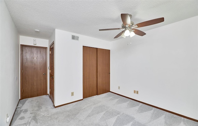 unfurnished bedroom with a textured ceiling, carpet flooring, and visible vents