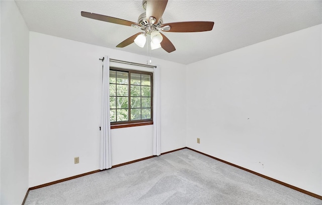 empty room with a textured ceiling, carpet flooring, and baseboards