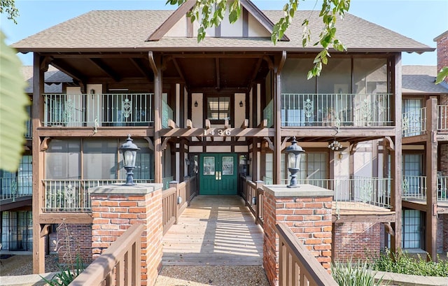 view of property featuring a shingled roof and stucco siding