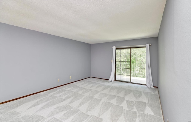 unfurnished room featuring a textured ceiling, carpet floors, and baseboards