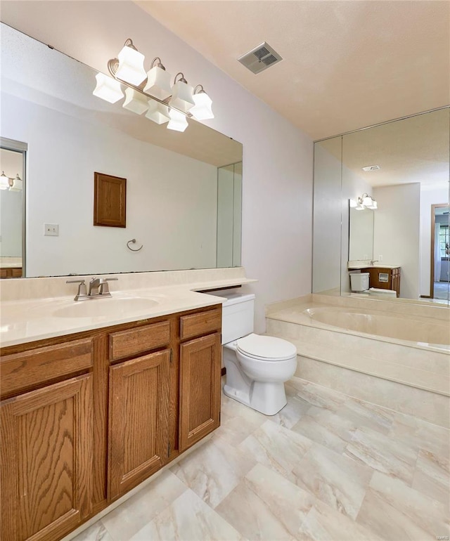 bathroom with visible vents, vanity, toilet, and a bath