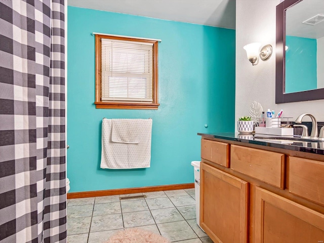 bathroom featuring tile patterned floors, walk in shower, vanity, and toilet