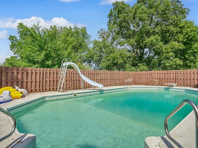 view of swimming pool with a water slide and a diving board