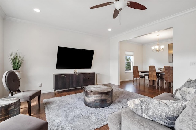 living room with crown molding, ceiling fan with notable chandelier, and dark hardwood / wood-style floors