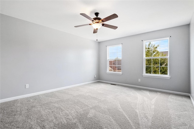 unfurnished room with ceiling fan and carpet