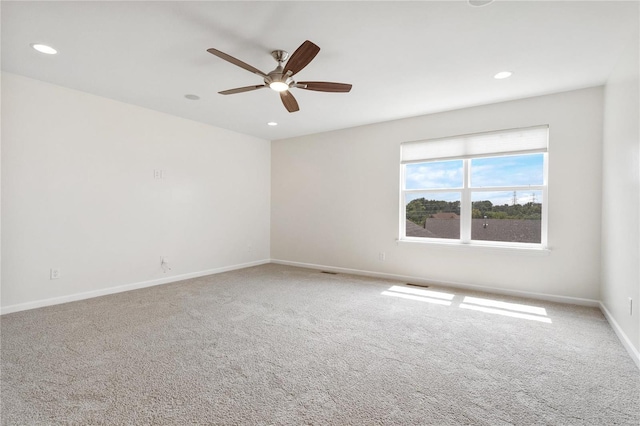 carpeted spare room featuring ceiling fan