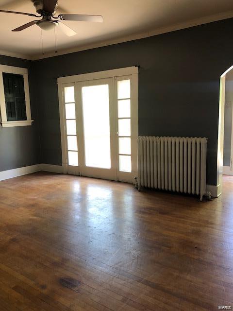 unfurnished room with ceiling fan, crown molding, hardwood / wood-style flooring, and radiator