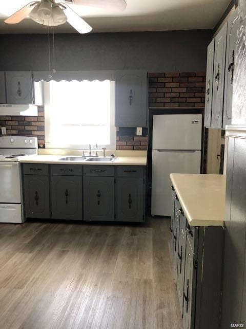 kitchen with sink, ceiling fan, white appliances, and light hardwood / wood-style floors