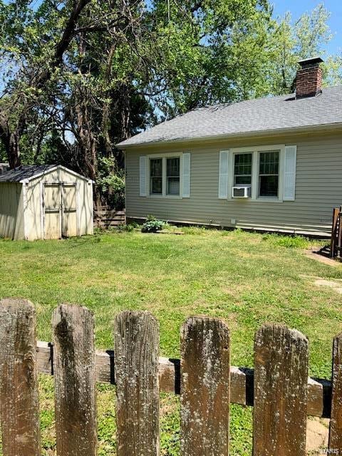 back of house featuring a shed and a yard