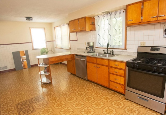 kitchen with tasteful backsplash, appliances with stainless steel finishes, light tile patterned flooring, and sink