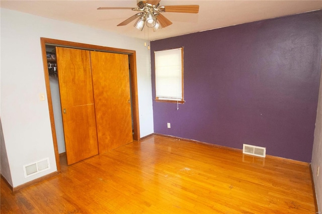 unfurnished bedroom with a closet, hardwood / wood-style floors, and ceiling fan