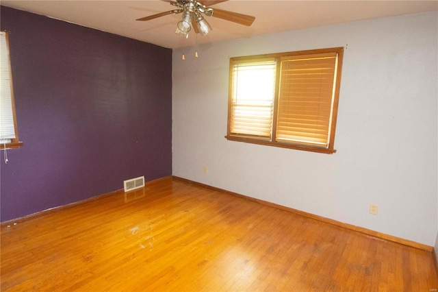 empty room with ceiling fan and hardwood / wood-style flooring