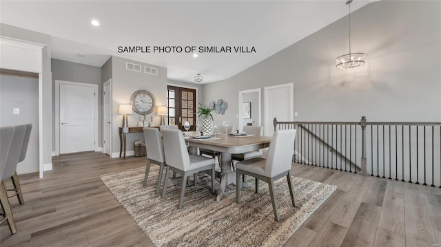 dining space with vaulted ceiling and light wood-type flooring