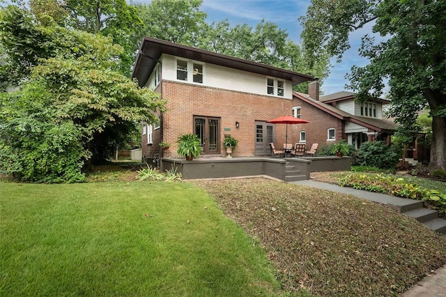 rear view of property with a patio and a yard