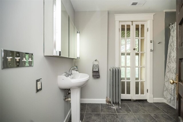 bathroom with radiator heating unit, french doors, and tile patterned flooring