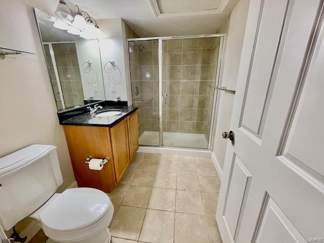 bathroom with an inviting chandelier, tile patterned flooring, an enclosed shower, toilet, and vanity