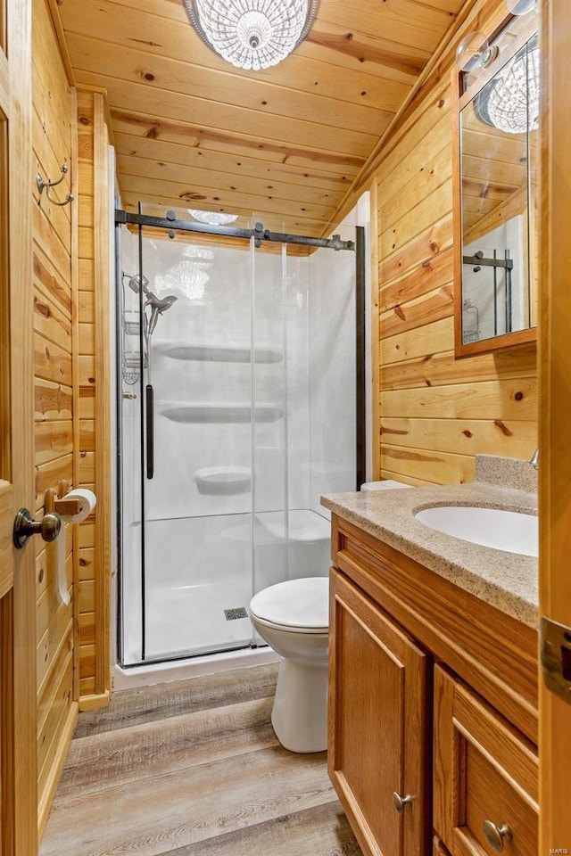 bathroom with wood-type flooring, wooden walls, vanity, wood ceiling, and toilet