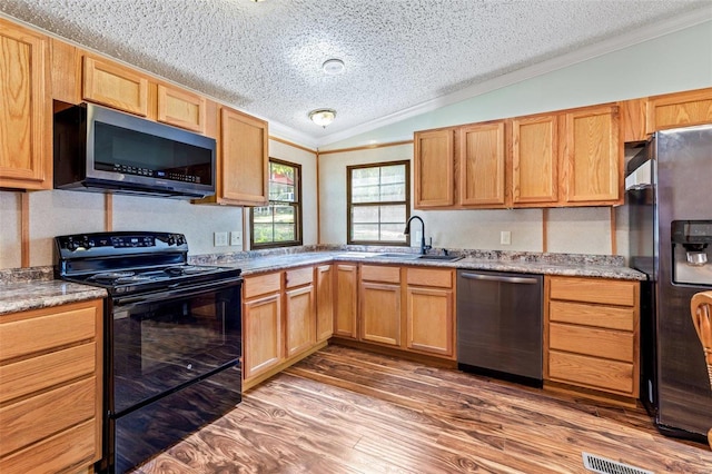 kitchen with ornamental molding, hardwood / wood-style flooring, a textured ceiling, black appliances, and lofted ceiling