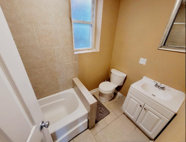 bathroom featuring tile patterned floors, a bathtub, vanity, and toilet