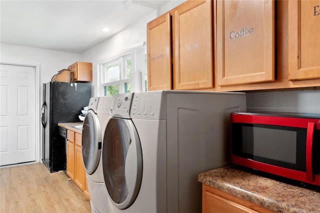 laundry area featuring washing machine and dryer and light wood-type flooring