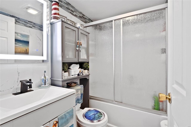 full bathroom featuring shower / bath combination with glass door, vanity, and toilet