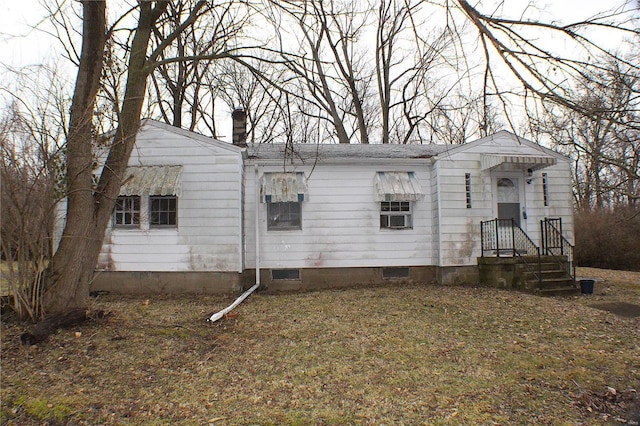 view of front of home featuring crawl space and a chimney