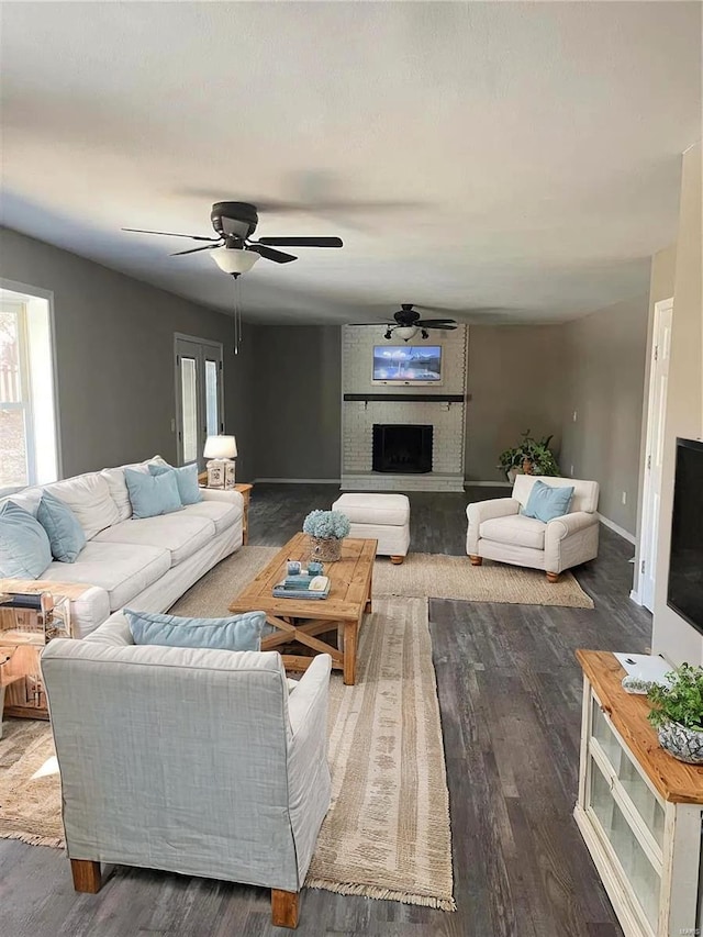 living room with ceiling fan, dark hardwood / wood-style floors, and a brick fireplace