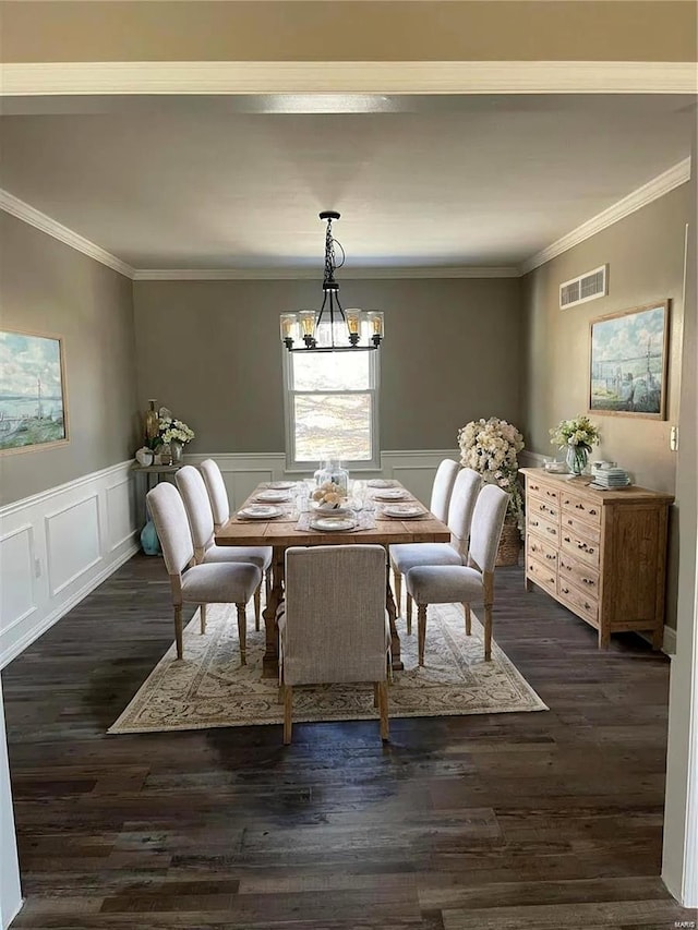 dining area featuring crown molding, dark hardwood / wood-style flooring, and a notable chandelier