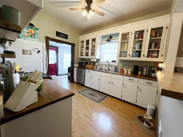 kitchen with white cabinets, plenty of natural light, light hardwood / wood-style floors, and dishwasher